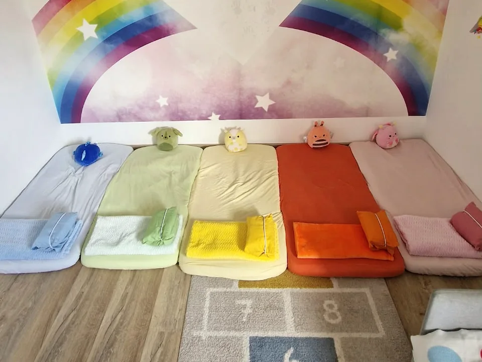 Aufgereihte Schlafmatten mit Decken und Kuscheltieren für die Mittagsruhe